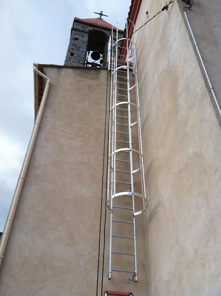Échelle à crinoline installée en façade pour l’accès au clocher-mur surmonté de sa croix